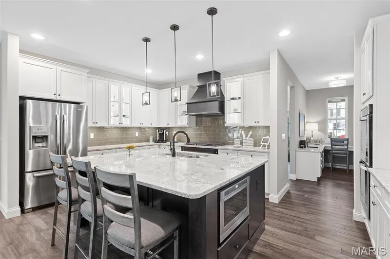 Kitchen with stainless steel appliances, decorative backsplash, white cabinetry, and recessed lighting — 1 TBB Kingston @Willow Grove, Dardenne Prairie, MO 63368