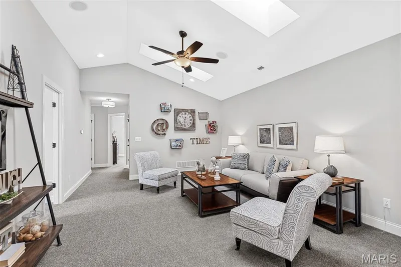 Living room featuring a skylight, light colored carpet, a ceiling fan, and high vaulted ceiling — 1 TBB Kingston @Willow Grove, Dardenne Prairie, MO 63368