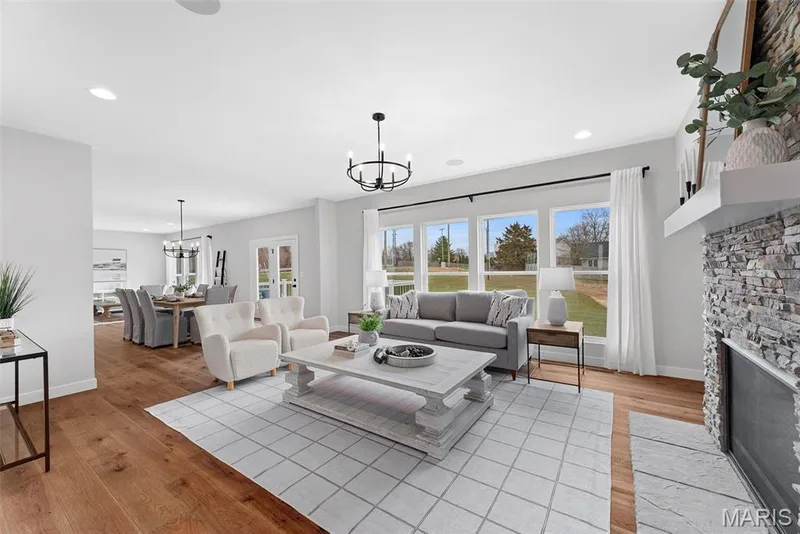 Living room featuring light wood-style floors, a fireplace, a chandelier, and recessed lighting — 1 TBB Bridgeport @ Chateau De Fond Du Lac, Lake St. Louis, MO 63367