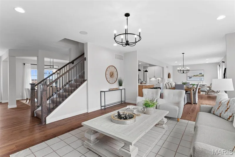 Living room with a chandelier, recessed lighting, light tile patterned floors, and stairway — 1 TBB Bridgeport @ Chateau De Fond Du Lac, Lake St. Louis, MO 63367