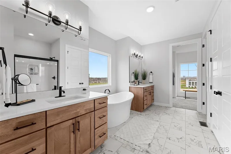 Full bath featuring a shower stall, two vanities, a freestanding tub, light marble finish flooring, and recessed lighting — 1 TBB Bridgeport @ Chateau De Fond Du Lac, Lake St. Louis, MO 63367