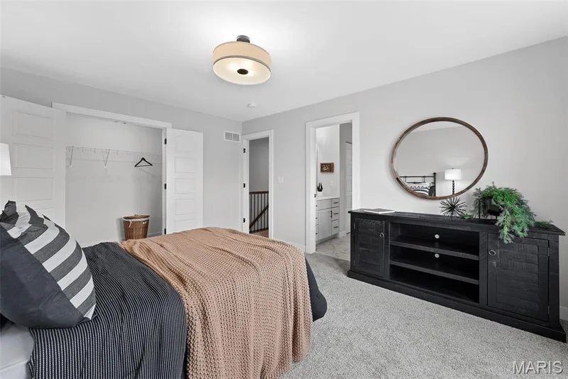 Bedroom with a closet, carpet flooring, and connected bathroom — 1 TBB Bridgeport @ Chateau De Fond Du Lac, Lake St. Louis, MO 63367
