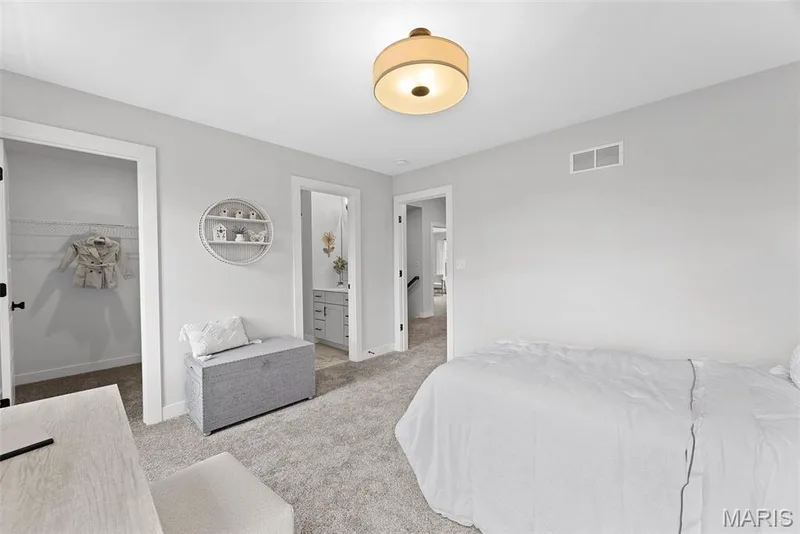 Bedroom with carpet floors, a walk in closet, and ensuite bathroom — 1 TBB Bridgeport @ Chateau De Fond Du Lac, Lake St. Louis, MO 63367