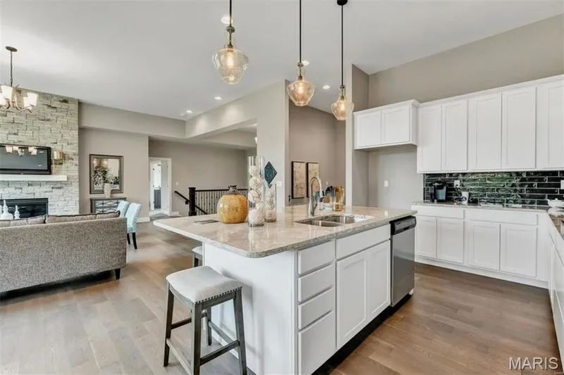 Kitchen with a center island with sink, white cabinets, backsplash, a kitchen breakfast bar, and recessed lighting — 1 TBB Monaco @ Chateau De Fond Du Lac, Lake St. Louis, MO 63367