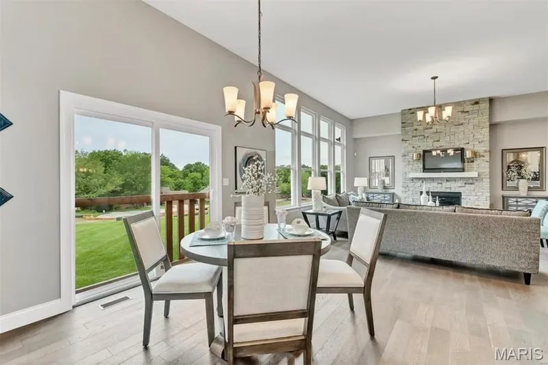 Dining room featuring a chandelier, a fireplace, and hardwood / wood-style flooring — 1 TBB Monaco @ Chateau De Fond Du Lac, Lake St. Louis, MO 63367
