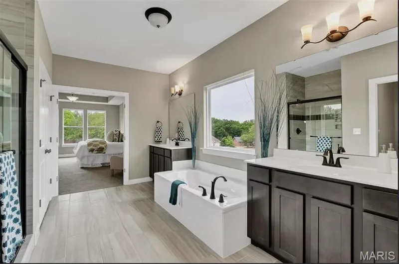 Ensuite bathroom featuring a shower stall, a garden tub, two vanities, and healthy amount of natural light — 1 TBB Monaco @ Chateau De Fond Du Lac, Lake St. Louis, MO 63367