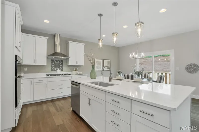 Kitchen with white cabinetry, dark wood finished floors, pendant lighting, recessed lighting, and a chandelier — 1 TBB Waverly @ Chateau De Fond Du Lac, Lake St. Louis, MO 63367