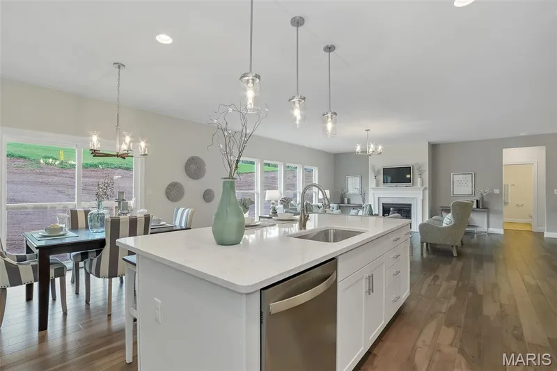 Kitchen with a chandelier, a fireplace, white cabinetry, stainless steel dishwasher, and dark wood-style floors — 1 TBB Waverly @ Chateau De Fond Du Lac, Lake St. Louis, MO 63367