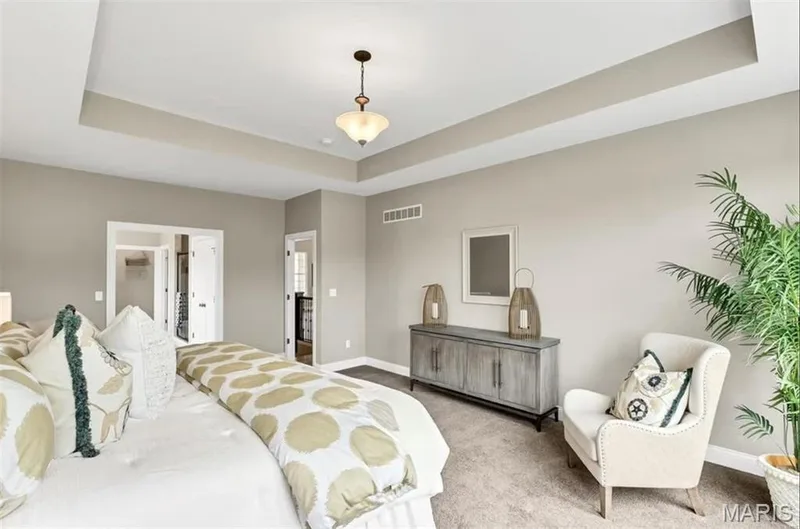 Carpeted bedroom with a raised ceiling and baseboards — 1 TBB Monaco @Willow Grove, Dardenne Prairie, MO 63368