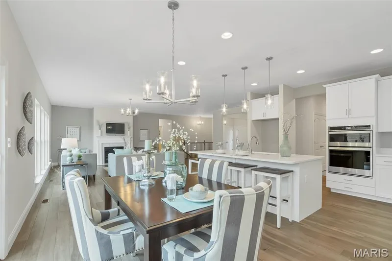 Dining area featuring a fireplace, light wood-style floors, recessed lighting, and a chandelier — 1 TBB Waverly @Willow Grove, Dardenne Prairie, MO 63368