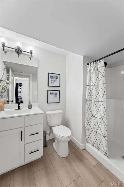 Full bathroom featuring a shower stall, vanity, and light wood-style floors — 1 TBB Canterbury@ Willow Grove, Dardenne Prairie, MO 63368
