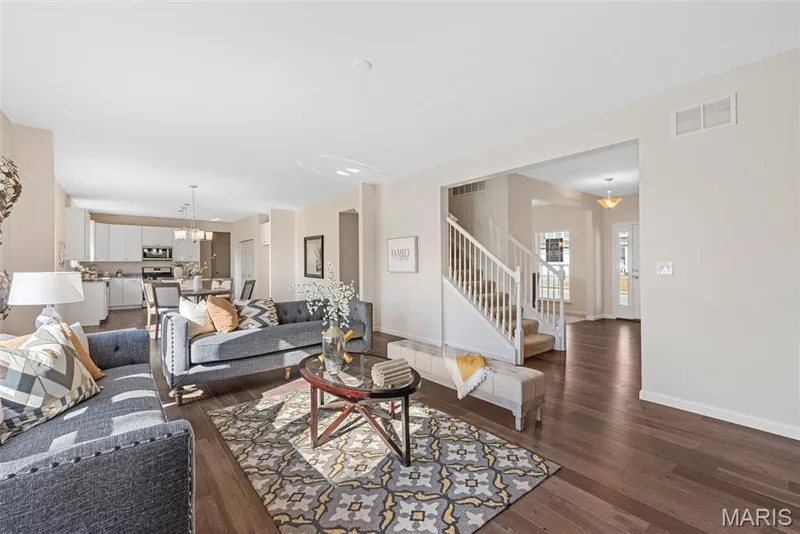 Living area with stairway, dark wood-style flooring, and a chandelier — 1 TBB Princeton @Willow Grove, Dardenne Prairie, MO 63368