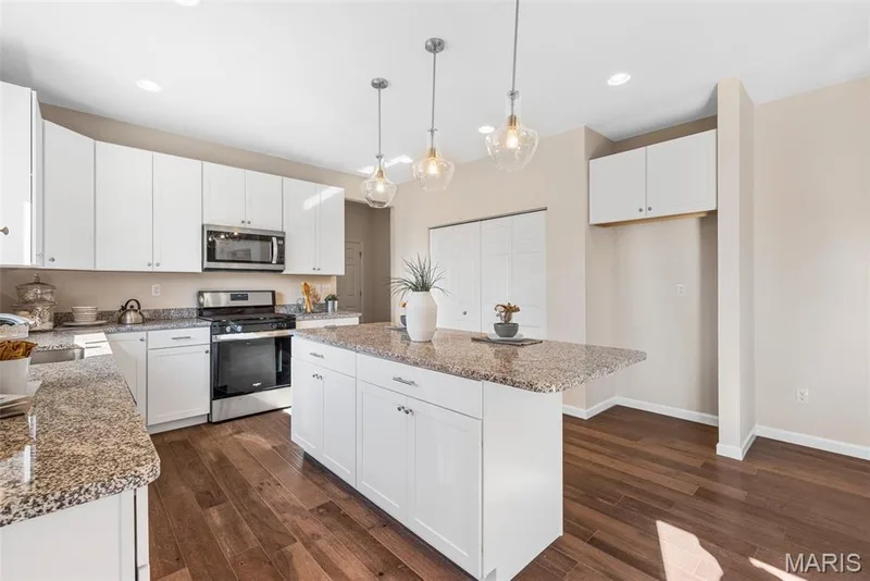Kitchen with appliances with stainless steel finishes, a center island, pendant lighting, white cabinetry, and dark wood-type flooring — 1 TBB Princeton @Willow Grove, Dardenne Prairie, MO 63368