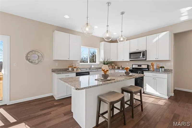 Kitchen featuring a kitchen breakfast bar, decorative light fixtures, white cabinetry, light stone countertops, and recessed lighting — 1 TBB Princeton @Willow Grove, Dardenne Prairie, MO 63368