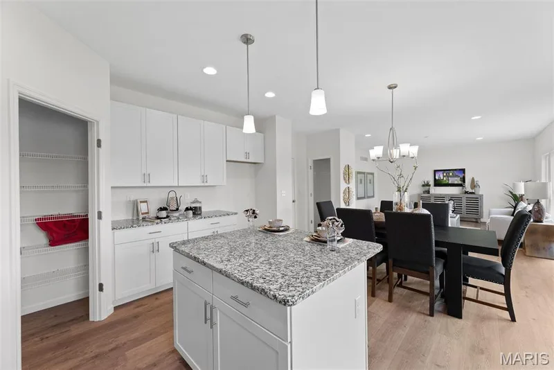 Kitchen with light wood-type flooring, open floor plan, light stone counters, decorative light fixtures, and recessed lighting — 1 TBB Barkley @ Creekside Sommers, O'Fallon, MO 63367