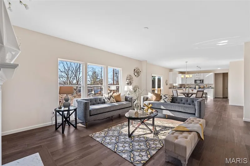 Living room featuring dark wood-style flooring and a chandelier — 1 TBB Princeton @ Creekside Sommers, O'Fallon, MO 63367