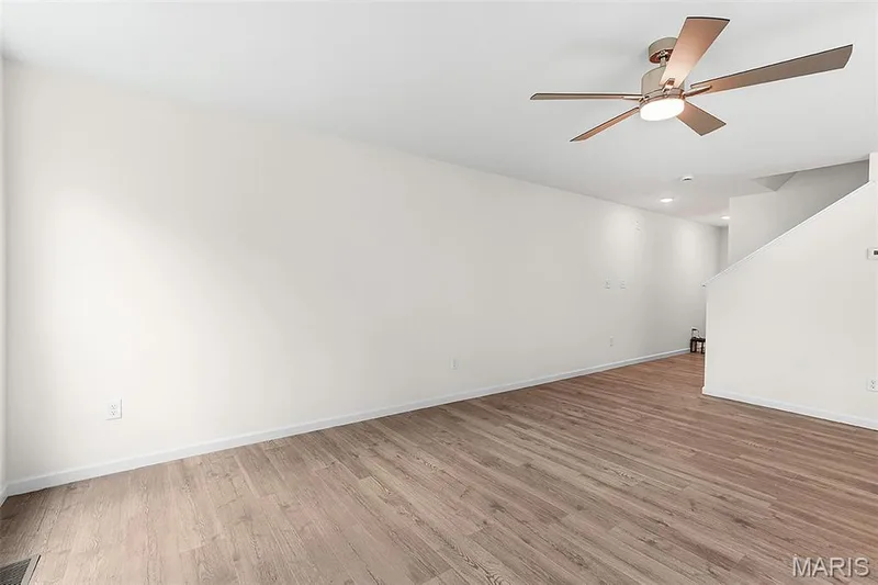 Empty room with light wood-style flooring and ceiling fan — 15 Integrity Court, O'Fallon, MO 63385
