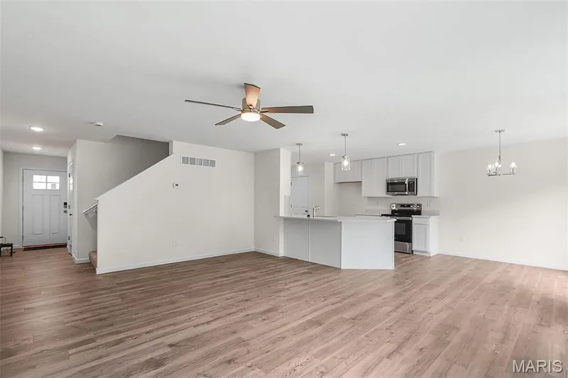 Unfurnished living room featuring light wood finished floors, a ceiling fan, a chandelier, and recessed lighting — 15 Integrity Court, O'Fallon, MO 63385