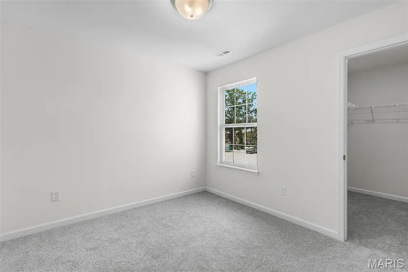 Unfurnished bedroom featuring a walk in closet and carpet — 15 Integrity Court, O'Fallon, MO 63385