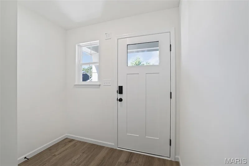 Entryway featuring dark wood-style floors and baseboards — 19 Integrity Court, O'Fallon, MO 63385