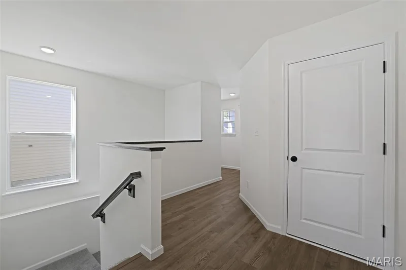 Hall with an upstairs landing and dark wood-type flooring — 19 Integrity Court, O'Fallon, MO 63385