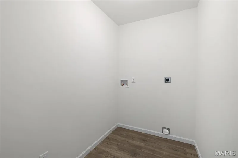 Washroom with electric dryer hookup, hookup for a washing machine, and dark wood-type flooring — 19 Integrity Court, O'Fallon, MO 63385