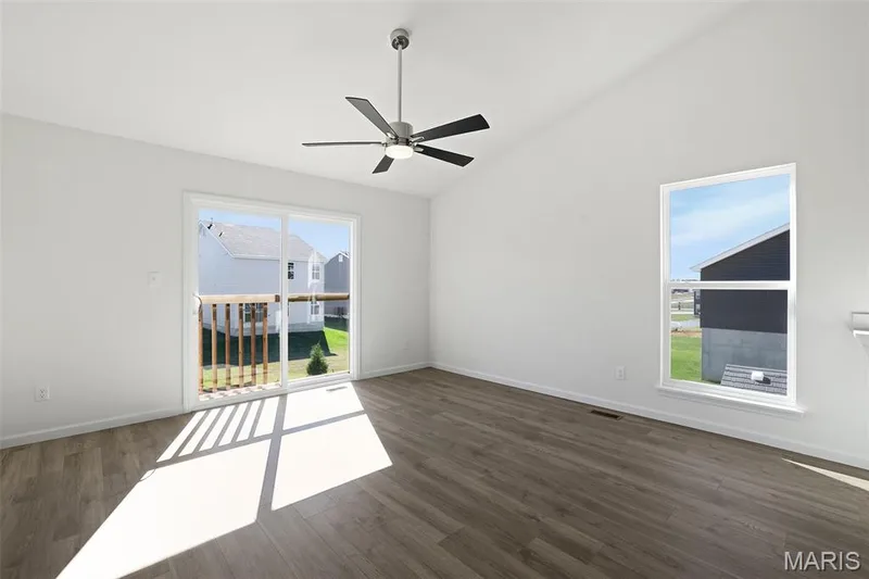 Empty room with vaulted ceiling, dark wood finished floors, and ceiling fan — 19 Integrity Court, O'Fallon, MO 63385