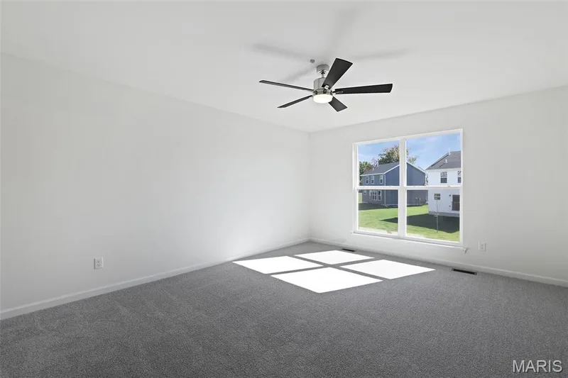 Carpeted spare room featuring baseboards and a ceiling fan — 19 Integrity Court, O'Fallon, MO 63385