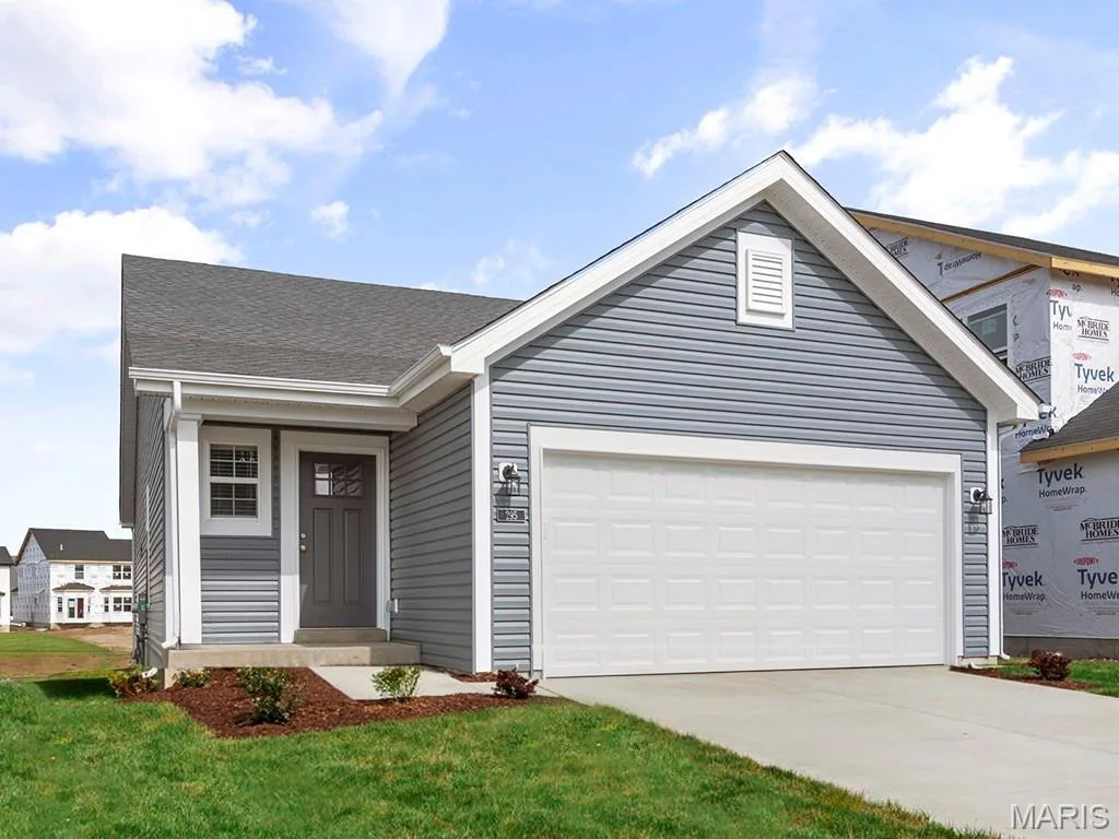 View of front facade with driveway, a garage, and a front lawn — 46 Integrity Court, O'Fallon, MO 63385