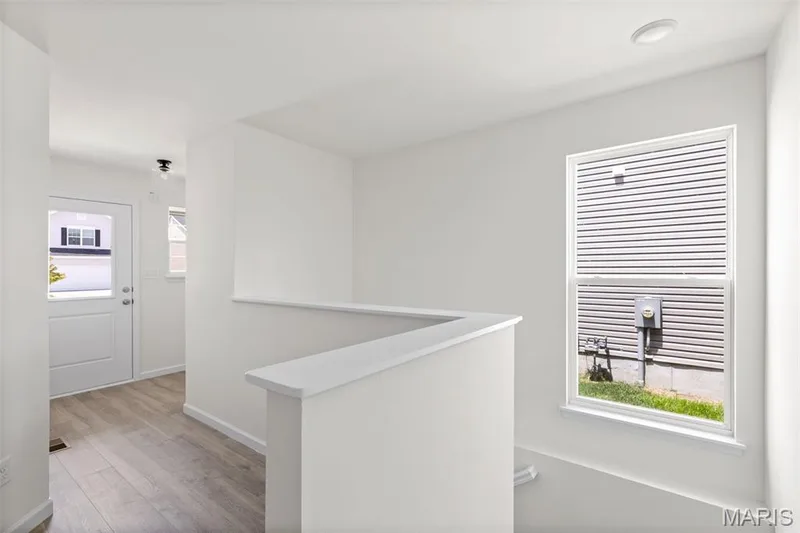 Hallway featuring an upstairs landing and light wood-style floors — 46 Integrity Court, O'Fallon, MO 63385