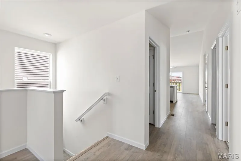 Corridor featuring an upstairs landing and wood finished floors — 46 Integrity Court, O'Fallon, MO 63385