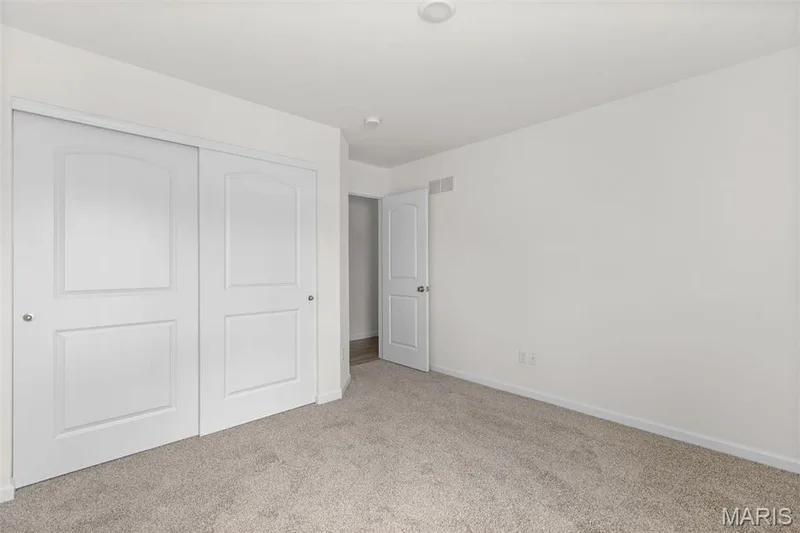 Unfurnished bedroom featuring light colored carpet and a closet — 46 Integrity Court, O'Fallon, MO 63385