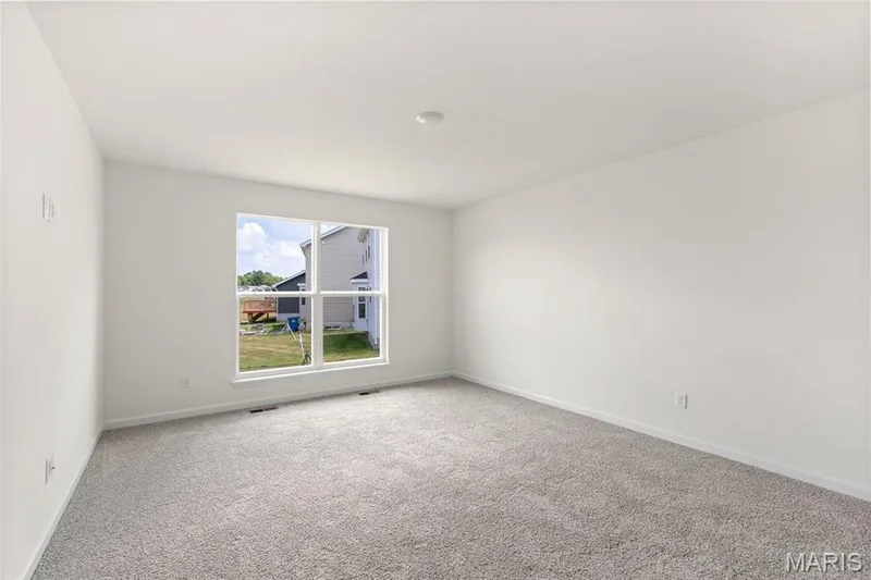 Empty room featuring light carpet and baseboards — 46 Integrity Court, O'Fallon, MO 63385