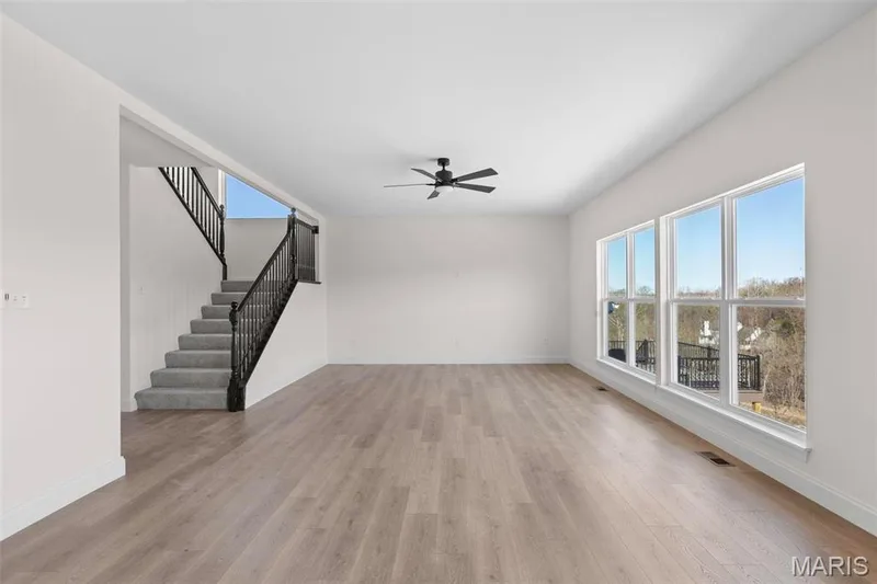 Unfurnished living room featuring ceiling fan, a healthy amount of sunlight, and light wood-type flooring — 3 Sequoia at Bluestem Estates, St Charles, MO 63367