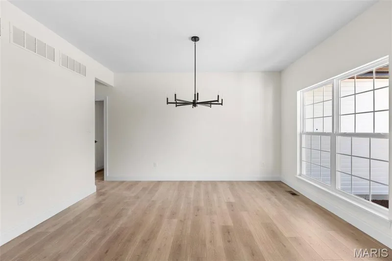 Unfurnished dining area with light hardwood / wood-style flooring and an inviting chandelier — 3 Sequoia at Bluestem Estates, St Charles, MO 63367