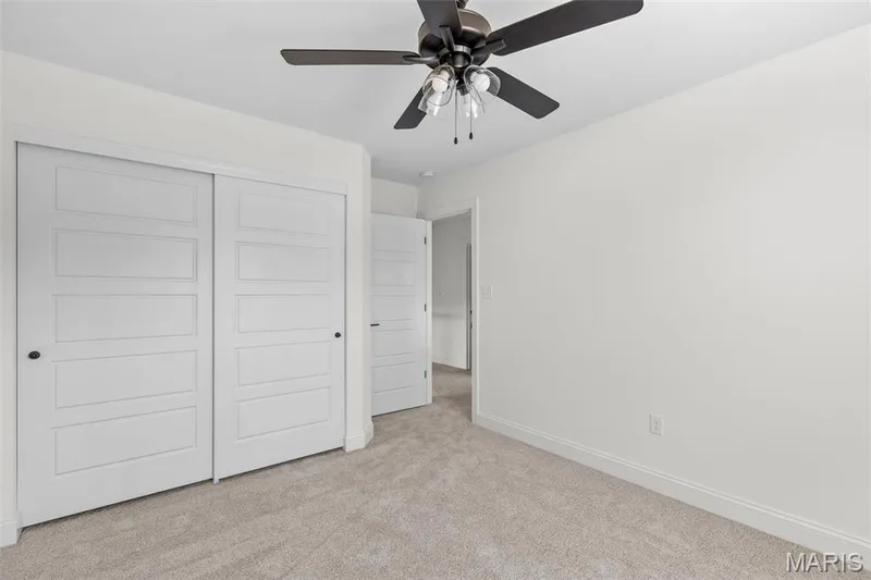 Unfurnished bedroom featuring ceiling fan, a closet, and light carpet — 3 Sequoia at Bluestem Estates, St Charles, MO 63367