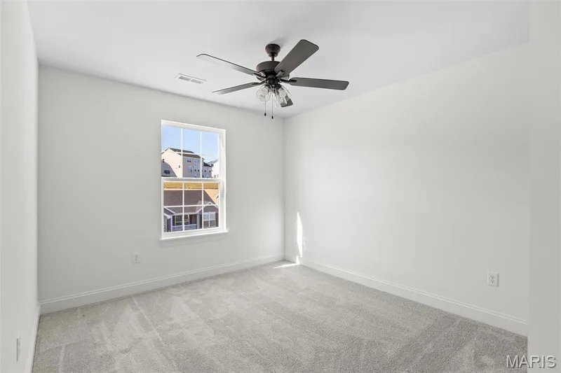 Empty room featuring ceiling fan and light colored carpet — 3 Sequoia at Bluestem Estates, St Charles, MO 63367