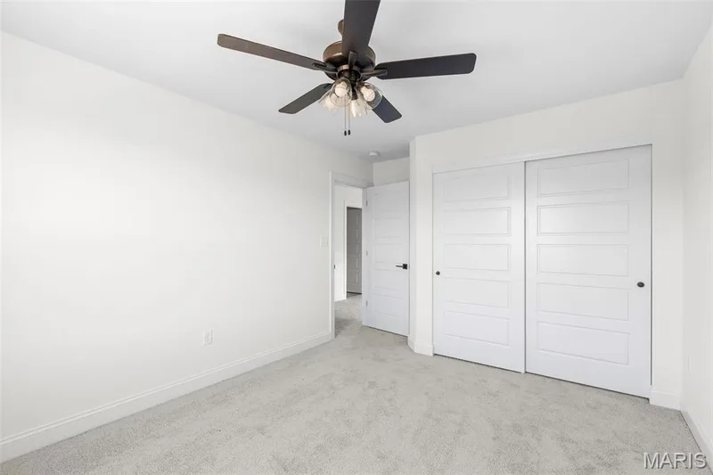 Unfurnished bedroom with ceiling fan, a closet, and light colored carpet — 3 Sequoia at Bluestem Estates, St Charles, MO 63367