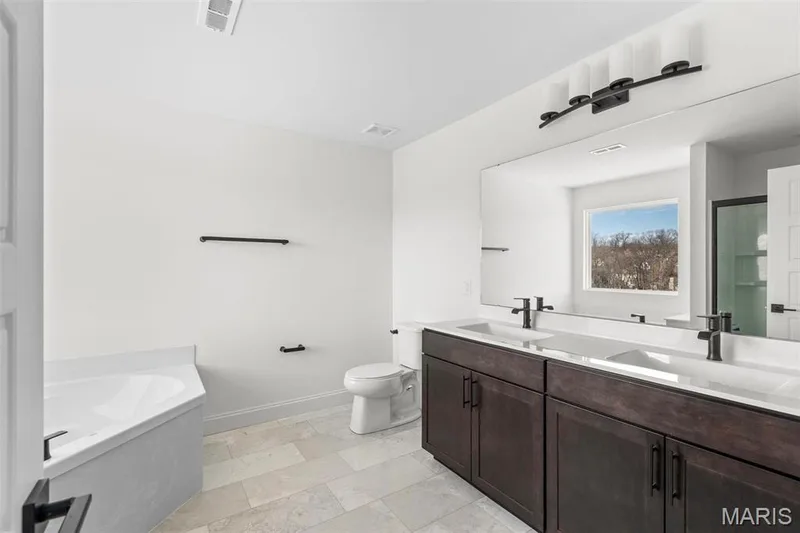 Full bathroom featuring vanity, toilet, and independent shower and bath — 3 Sequoia at Bluestem Estates, St Charles, MO 63367
