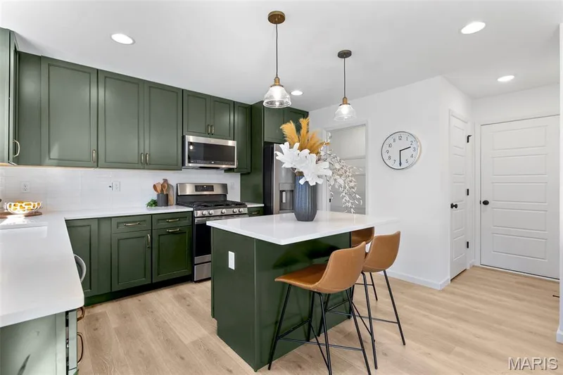 Kitchen featuring green cabinetry, stainless steel appliances, a center island, decorative light fixtures, and recessed lighting — 3 Sterling at Westhaven, Wentzville, MO 63385