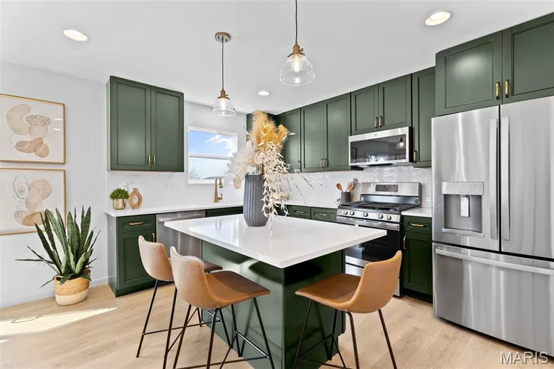 Kitchen with green cabinets, stainless steel appliances, a center island, and recessed lighting — 3 Sterling at Westhaven, Wentzville, MO 63385
