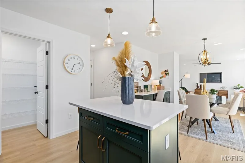 Kitchen featuring hanging light fixtures, green cabinets, light countertops, light wood finished floors, and recessed lighting — 3 Sterling at Elm Crossing, St Charles, MO 63301