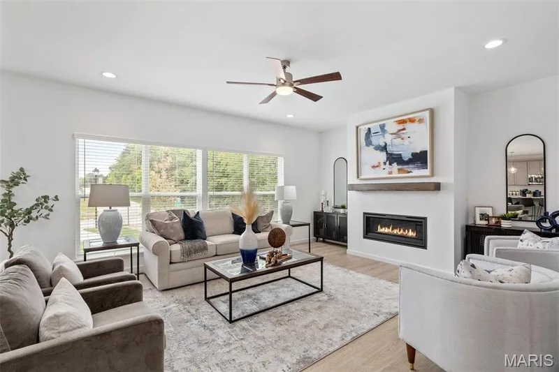 Living room with light hardwood / wood-style floors and ceiling fan — 3 Ashford at Elm Crossing, St Charles, MO 63301