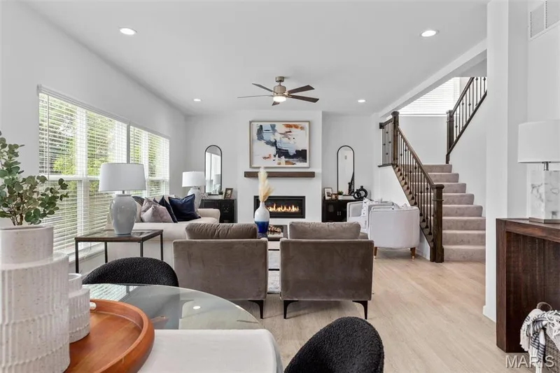 Living room with ceiling fan and light wood-type flooring — 3 Ashford at Elm Crossing, St Charles, MO 63301