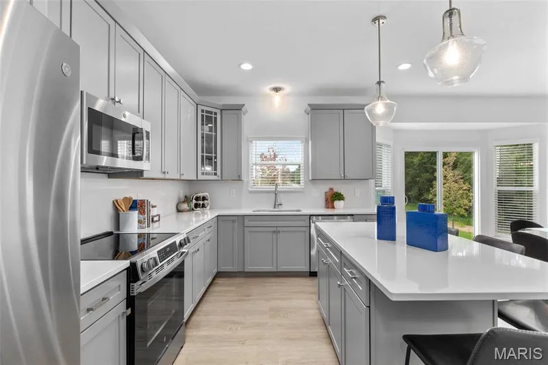 Kitchen featuring pendant lighting, a wealth of natural light, appliances with stainless steel finishes, and sink — 3 Ashford at Elm Crossing, St Charles, MO 63301