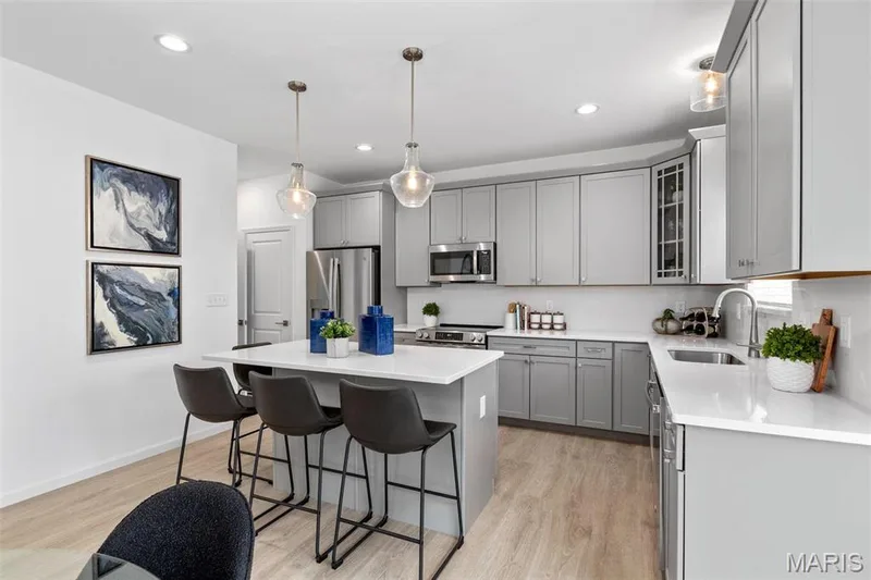 Kitchen featuring hanging light fixtures, sink, a kitchen island, gray cabinets, and stainless steel appliances — 3 Ashford at Elm Crossing, St Charles, MO 63301