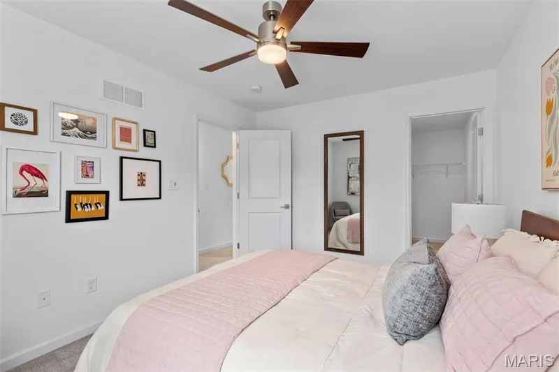 Bedroom featuring ceiling fan, a closet, light carpet, and a spacious closet — 3 Ashford at Elm Crossing, St Charles, MO 63301