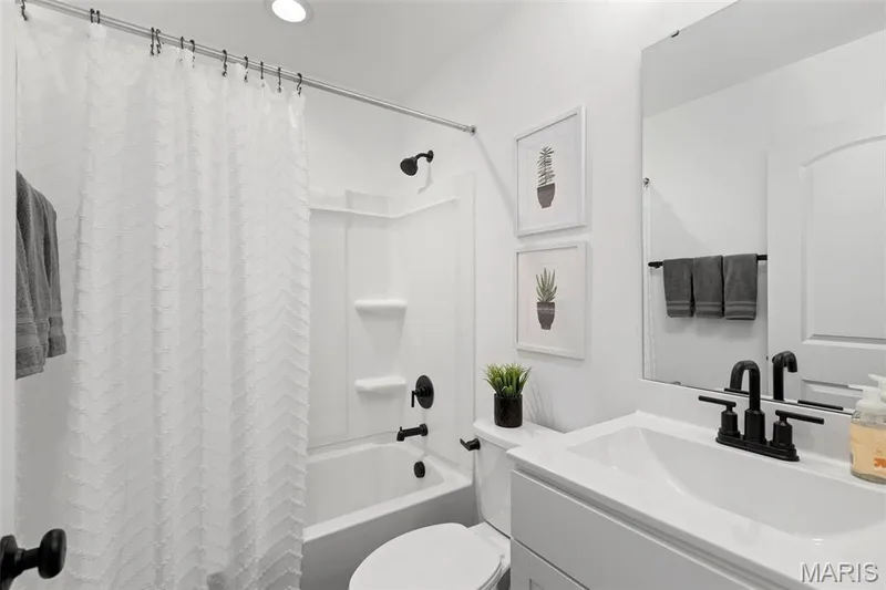 Full bathroom featuring vanity, toilet, and shower / bath combo with shower curtain — 3 Aspen at Elm Crossing, St Charles, MO 63301