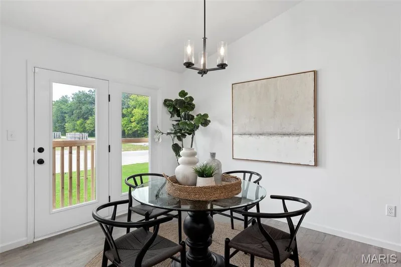 Dining space featuring hardwood / wood-style flooring, lofted ceiling, and a notable chandelier — 3 Aspen at Elm Crossing, St Charles, MO 63301