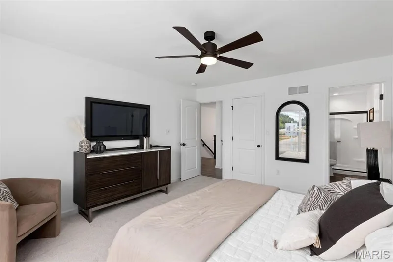 Bedroom featuring ceiling fan, connected bathroom, and light carpet — 3 Aspen at Elm Crossing, St Charles, MO 63301